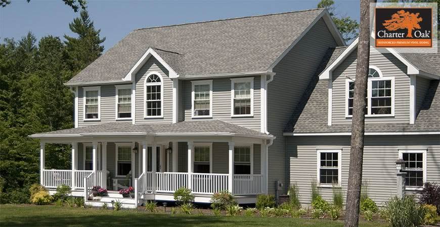 Professional siding installation on a large two-story house with gray lap siding and covered porch