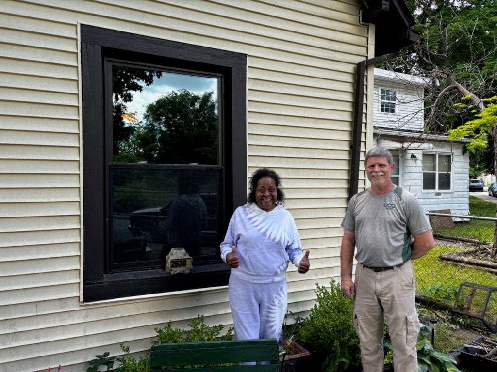 Johnnie Ray Pennington, the owner of The Window Source of Indy is posing with another homeowner and her newly installed window. The Window Source of Indy recently partnered with Rebuilding Together Indianapolis on this project.